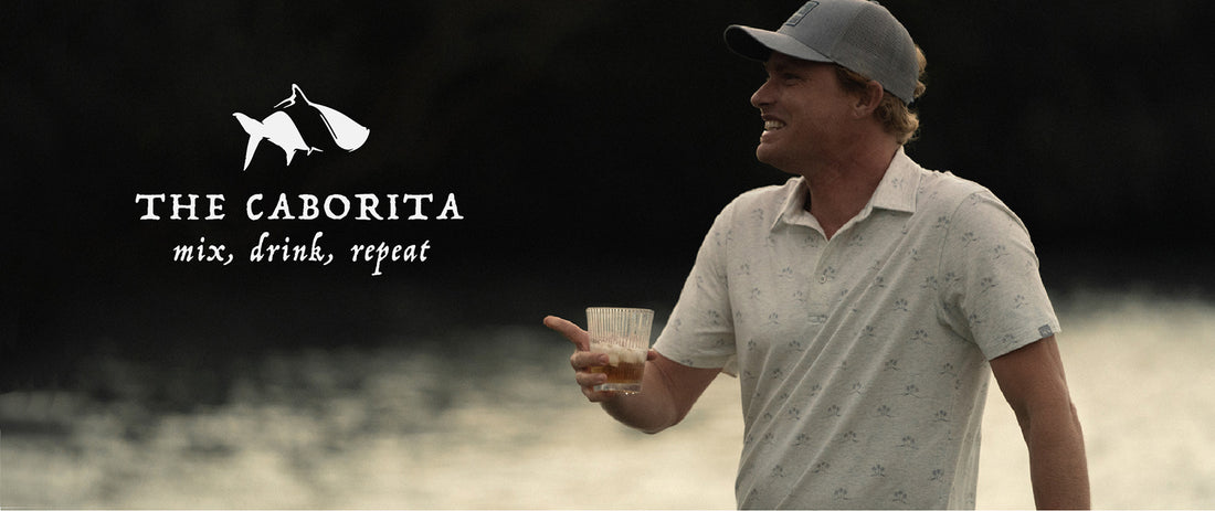 man smiling near ocean with margarita drink in hand
